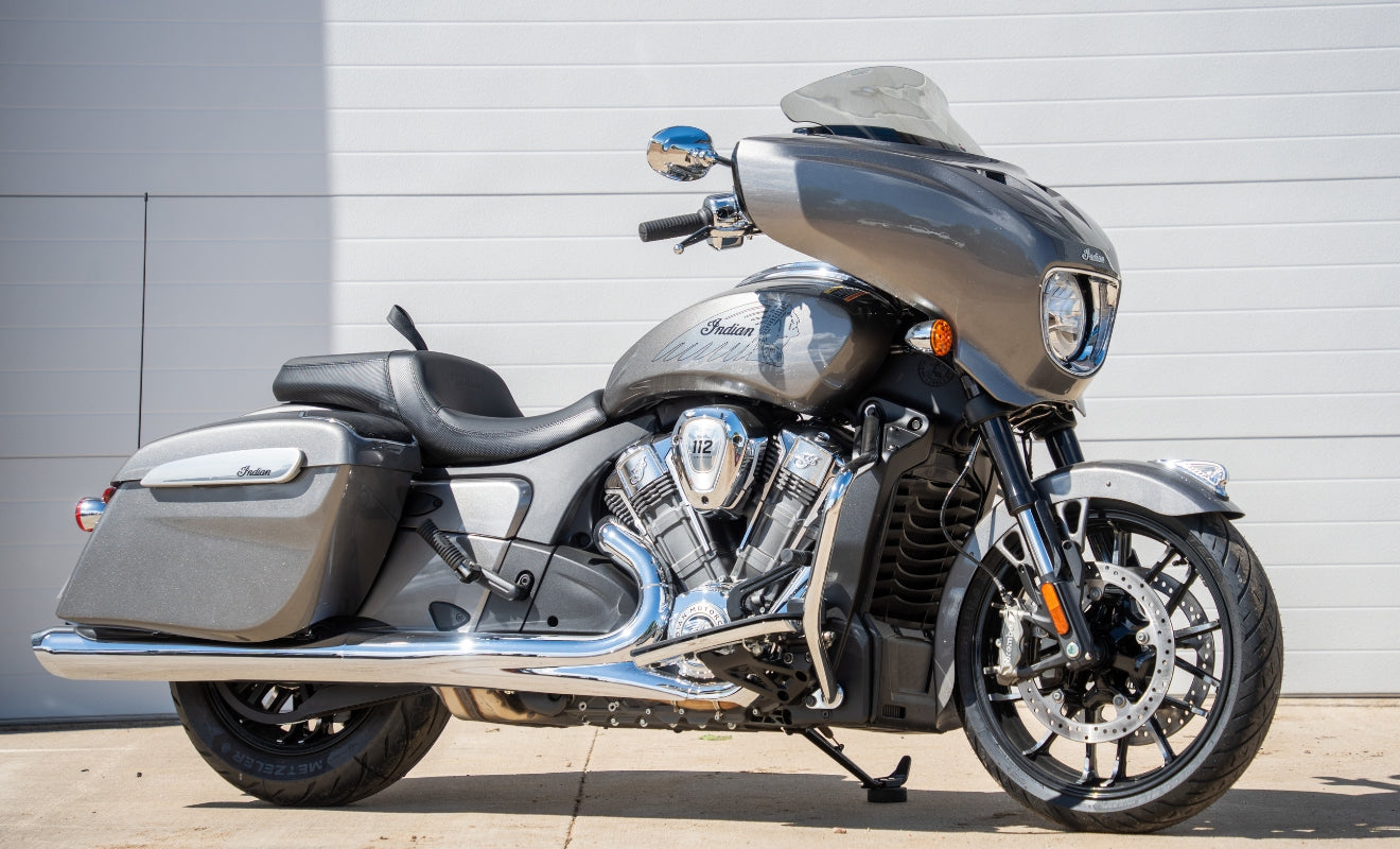 Custom Indian Motorcycle with grey paint, chrome accents, and a tinted Flare windshield sitting outside during the day in front of a white garage door at Klock Werks in Mitchell South Dakota.