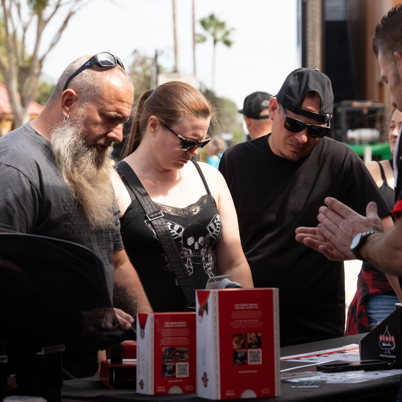 Motorcyclists at a motorcycle rally vendor lot looking at Klock Werks iOmounts and Flare Windshield parts and accessories for motorcycles.
