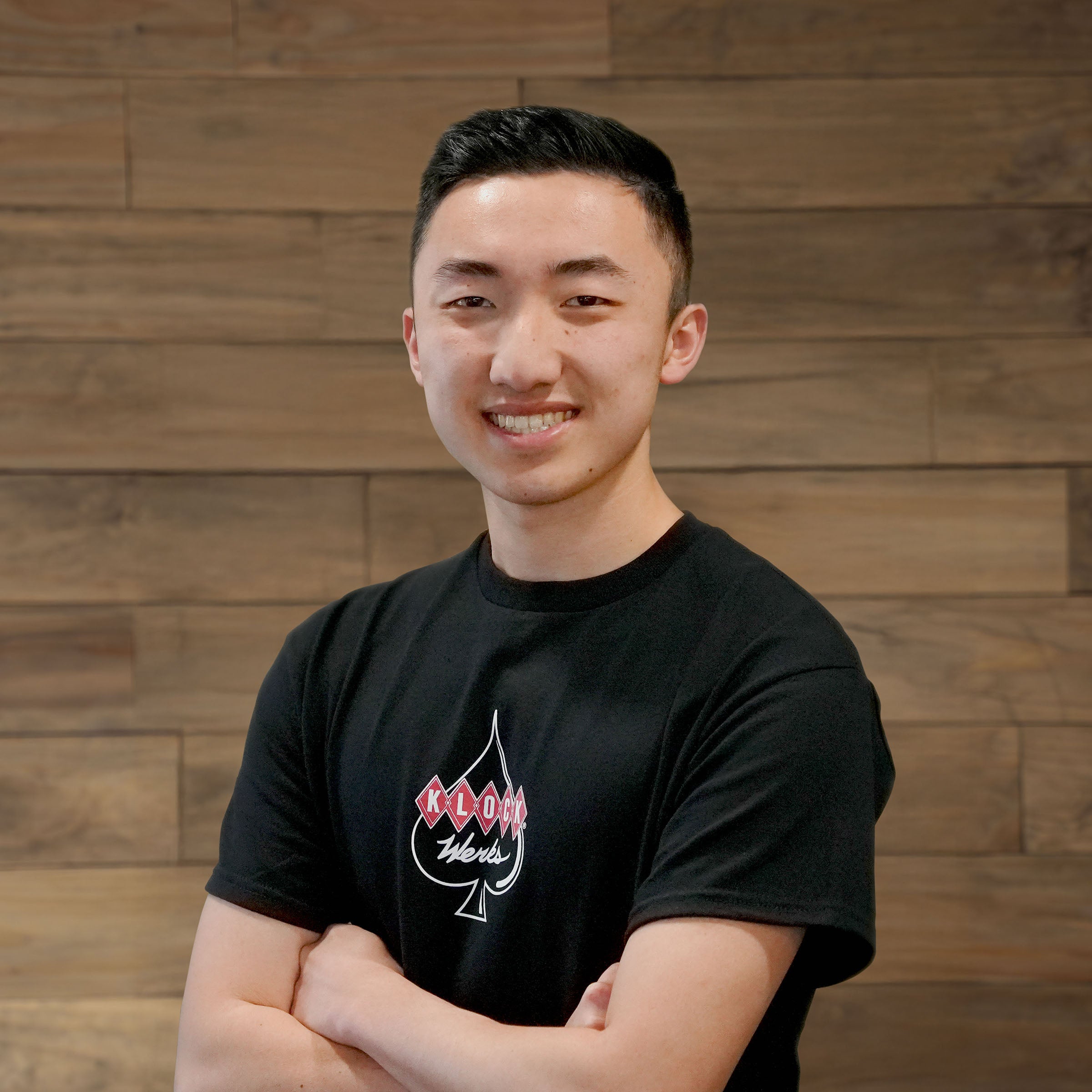 Jesse Dodd poses in front of a wooden backdrop for his Klock Werks employee photo.