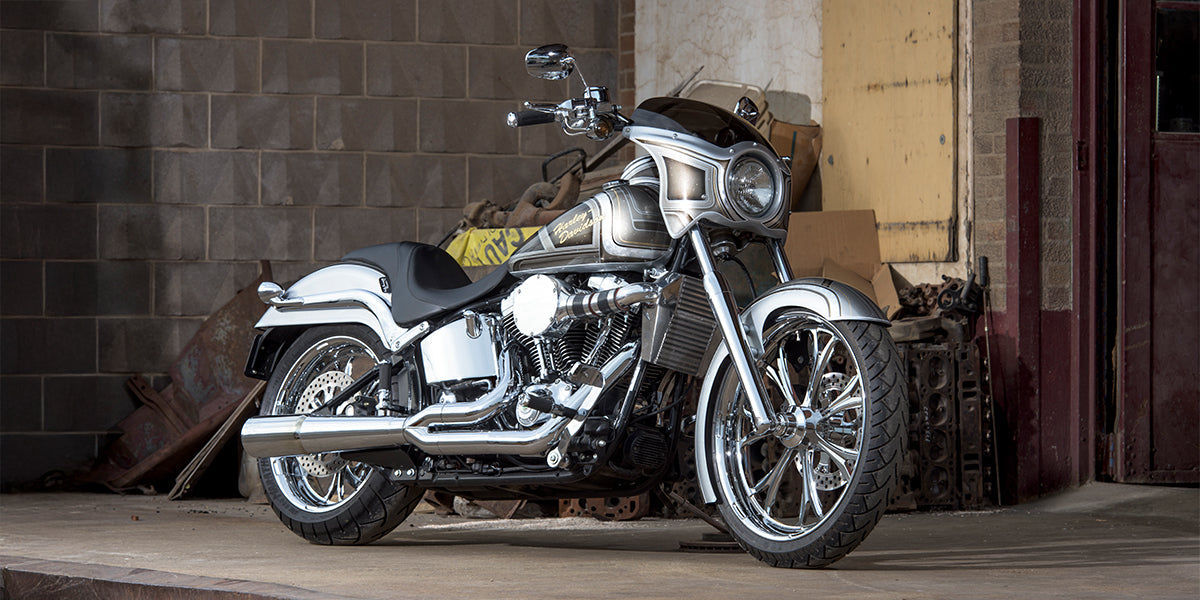 Klock Werks custom 2003 Harley-Davidson Softail Deuce featuring Klock Werks fairing, wide front wheel, chrome details, and custom paint, photographed in an industrial setting.