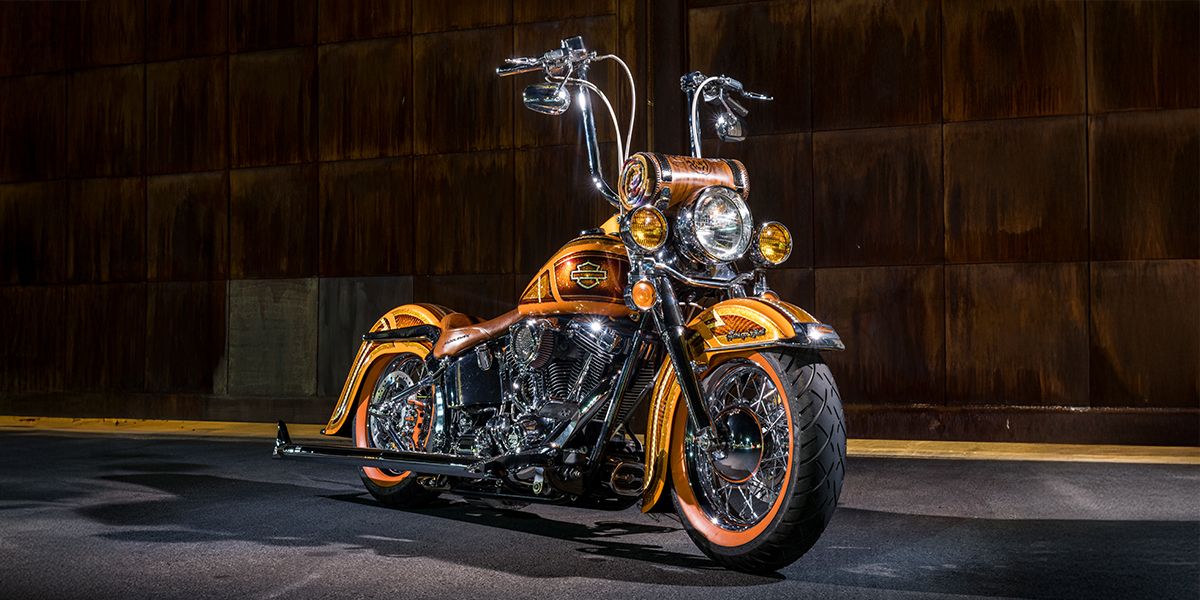 Klock Werks custom 2004 Harley-Davidson® Softail wide-shot, showcasing the candy orange paintwork, chrome accents, and the gold flakes.