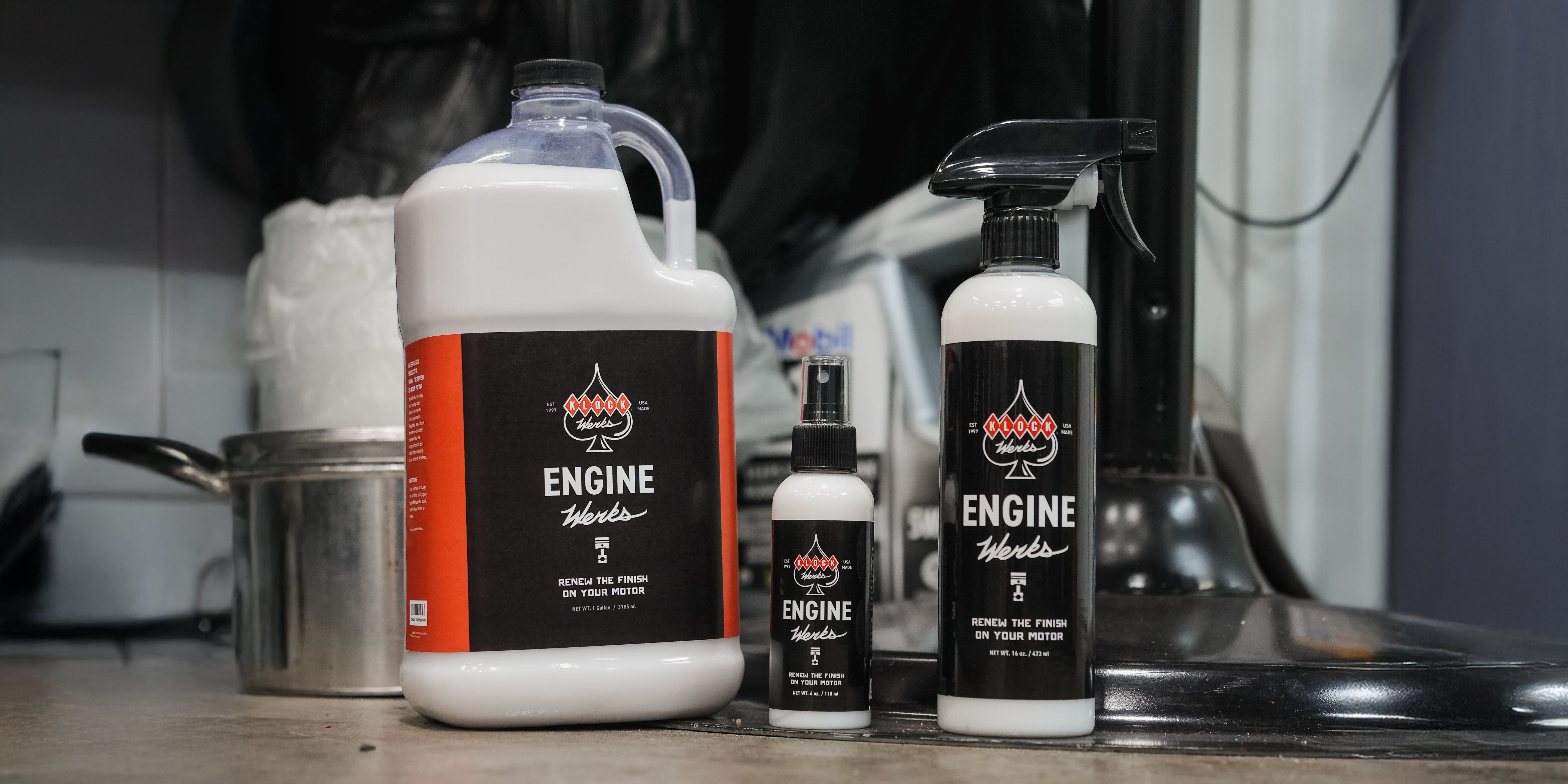 The best motorcycle engine cleaner, Engine Werks, bottles in gallon, 16oz, and 4oz sizes lined up.