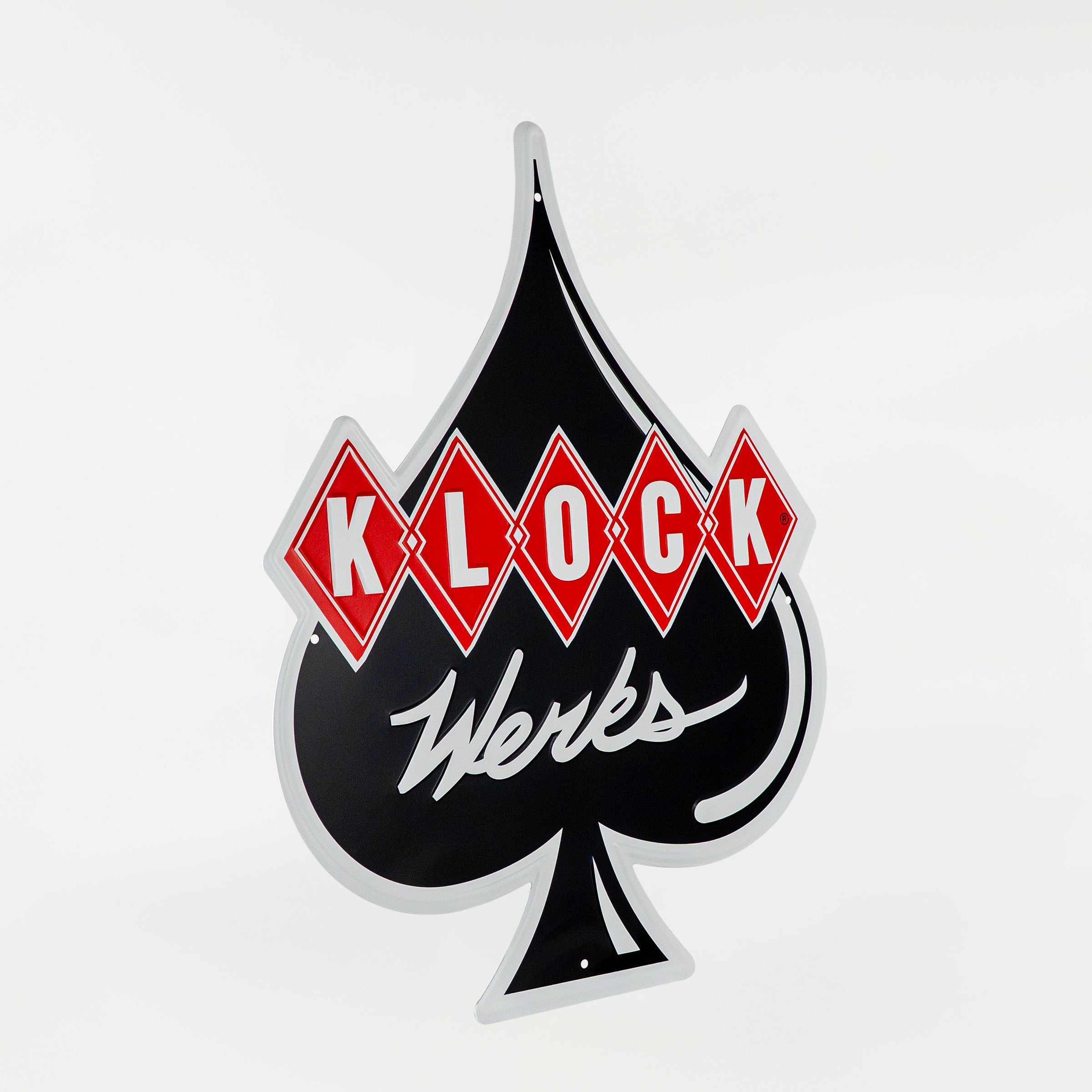 A vintage-style metal sign shaped like a black spade with red diamond tiles spelling 'KLOCK' and white script reading 'Werks' underneath, shown on a light gray background.